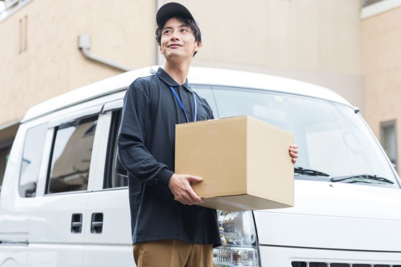 走りながら小包を運ぶ女性スタッフ